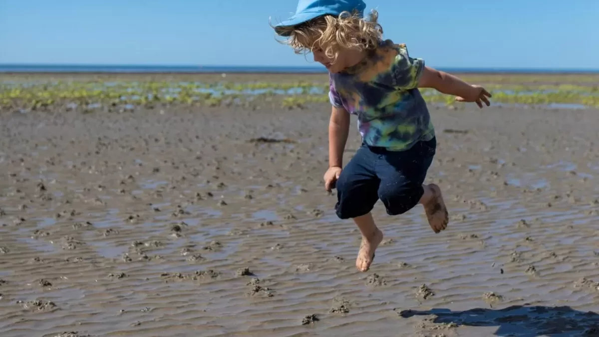 child jumping in the sand