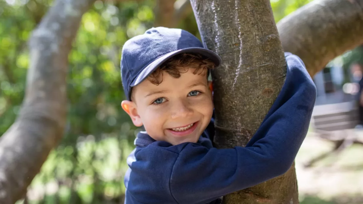 child hugging a tree