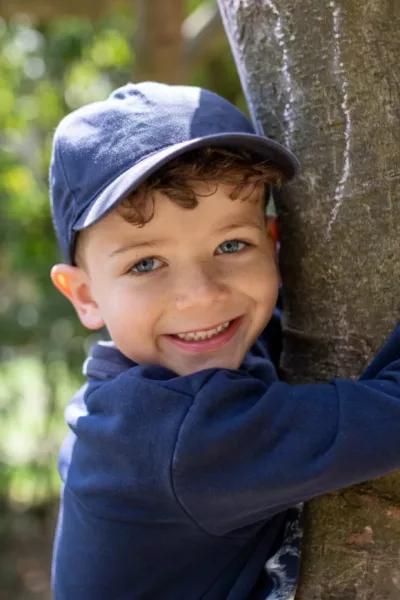 child hugging a tree