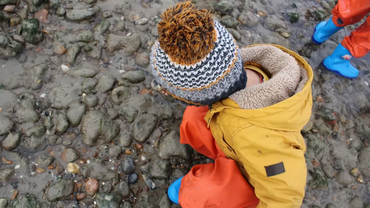 Child on the ground looking at stones