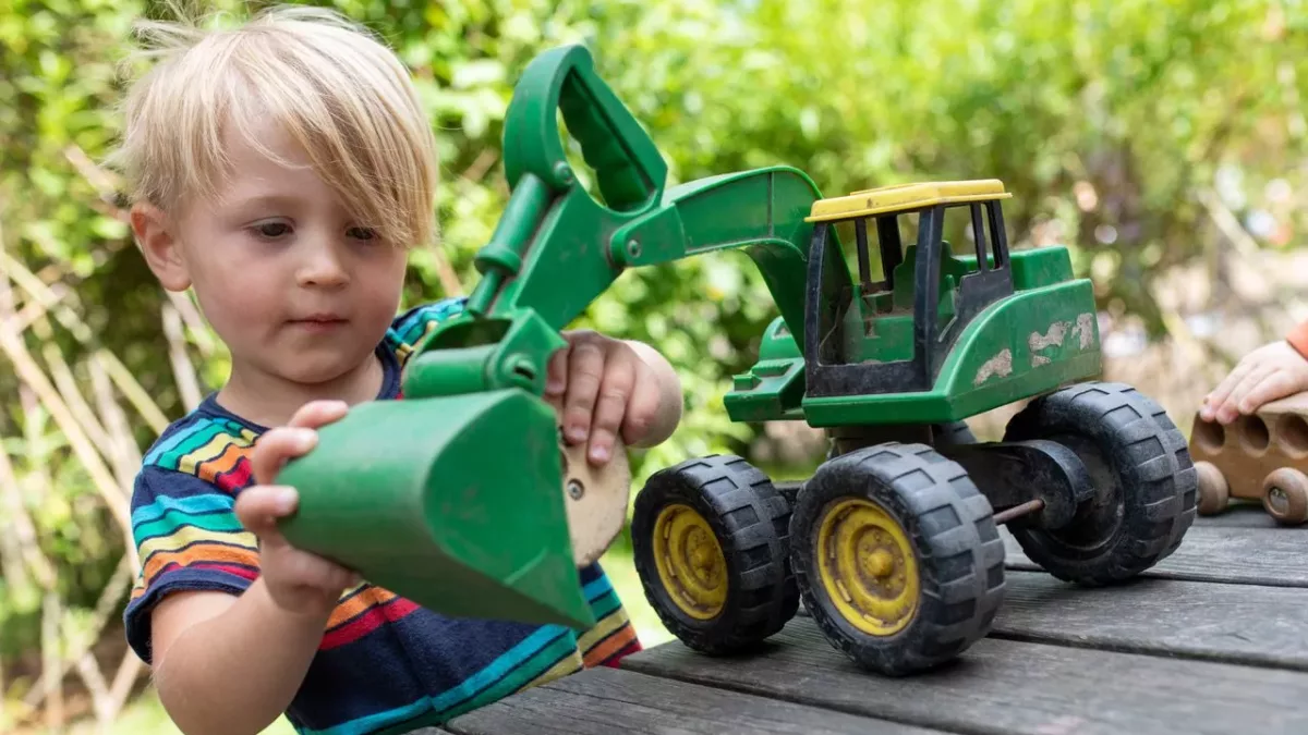 a child looking at a digger toy