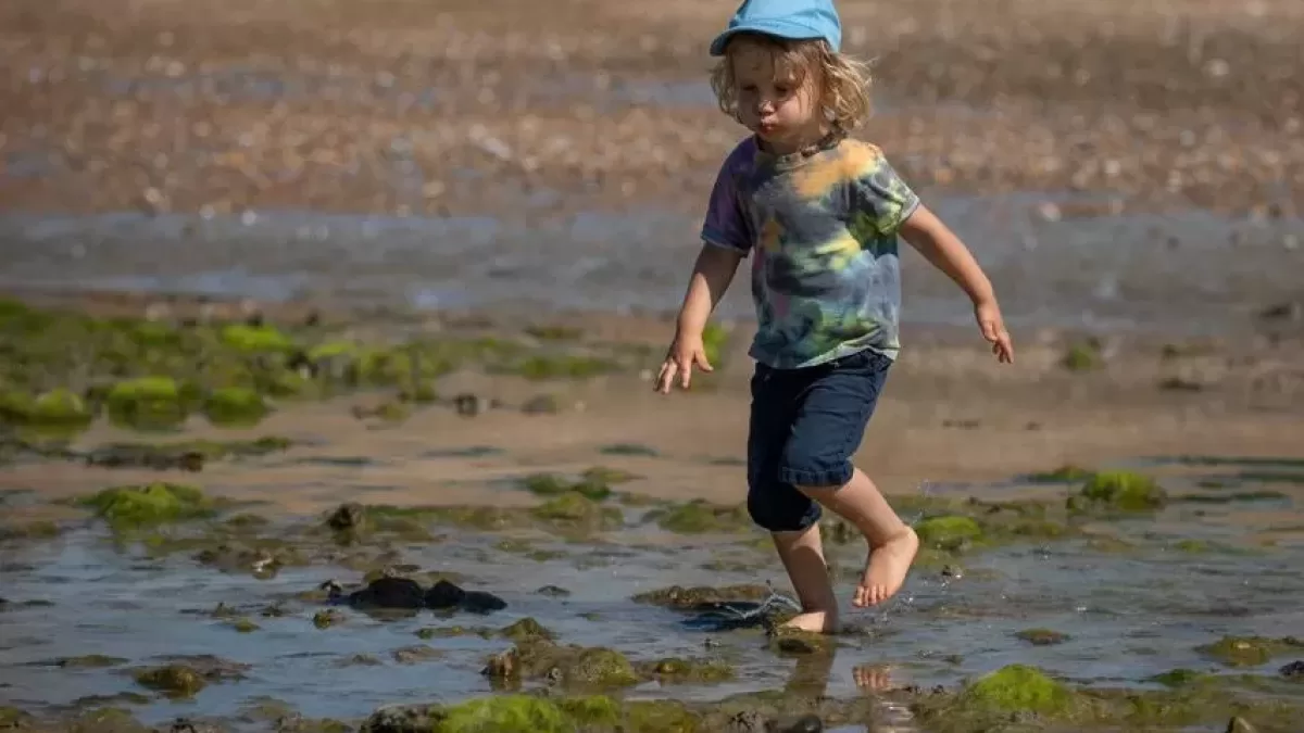 child running across the wet sand