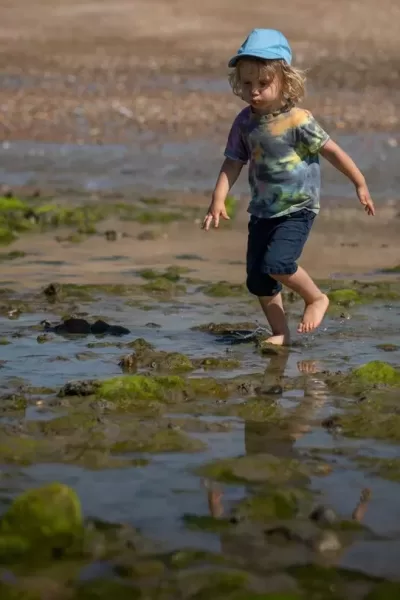 child running across the wet sand
